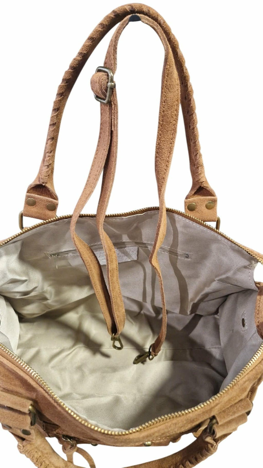 Intérieur spacieux du grand sac à main en daim Jolies Folies avec doublure beige, anses tressées et bandoulière.